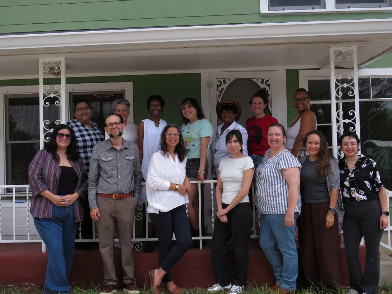 A group of people standing together on a porch.